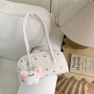 Close-up of cream shoulder bag with floral pattern and cute white rabbit plush charm