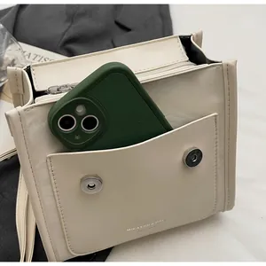 Detail view of the durable front pocket showing capacity with a smartphone inside