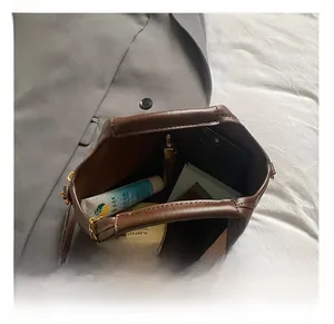Vue de dessus de l'intérieur du sac en cuir marron montrant le grand espace de rangement