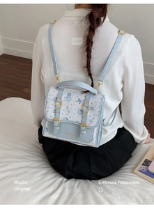 Detail view of the mini backpack with blue bear prints and textured fabric finish