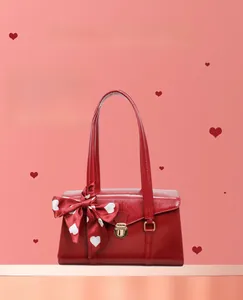 Détail du sac de mariée rouge avec texture brillante et foulard en soie à motifs de cœur