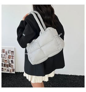 Rückansicht eines Models mit einer hellgrau gesteppten Puffer-Tasche und Kordelzug-Details