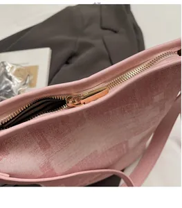 Dettaglio ravvicinato della cerniera metallica dorata su borsa a secchiello rosa jacquard