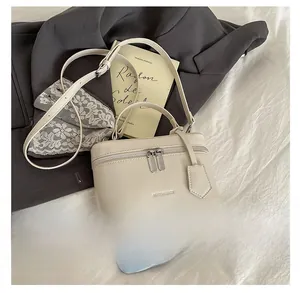 Detail view of the beige square box bag showing the MIAOSHEBAGS logo and side pendant