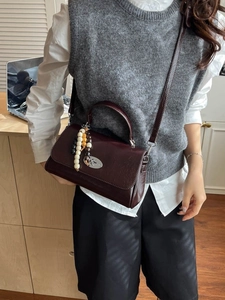 Retro burgundy leather crossbody handbag with elegant oval clasp and decorative beads