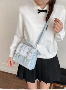 Detail of light blue and white satchel with cartoon bears and gold buckle closure
