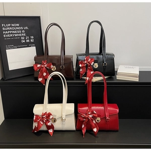 Détail de sacs à main élégants avec imprimés cœurs et nœuds rouges festifs et boucles dorées