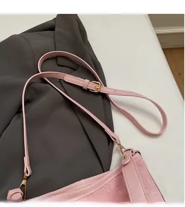 Dettaglio borsa a secchiello rosa testurizzata con tracolla e fibbie dorate