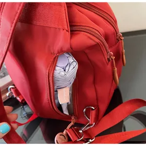 Dettaglio della tasca laterale dello zaino in nylon rosso con ombrello viola