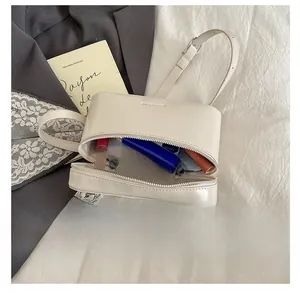 Detailed interior view of compact cream cylinder bag showing storage capacity for cosmetics
