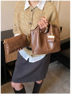 Gros plan détaillé d'un sac cabas en cuir souple marron foncé avec sa pochette zippée