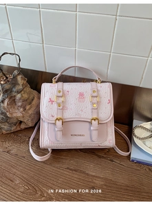 Detailed view of light pink preppy backpack with cute cartoon prints and metal buckle