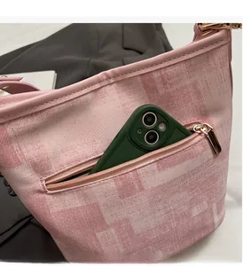 Dettaglio della funzionale tasca esterna con cerniera su una borsa a secchiello rosa