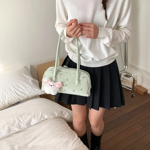 Detail view of mint green floral shoulder bag with a cute plush puppy charm accessory