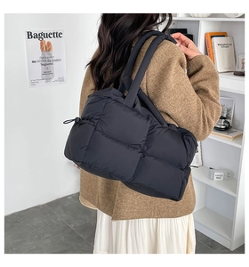 Rückansicht eines Models mit einer schwarzen gesteppten Puffer-Tasche mit Karomuster