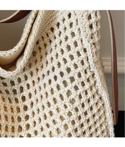 Close-up of woven tote bag showing hollow diamond crochet texture and leather strap