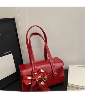 Détail du sac de mariée rouge avec fermoir doré rotatif et ruban à pois élégant
