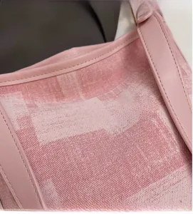 Dettaglio della trama della borsa a secchiello tessuta rosa con motivo a quadri