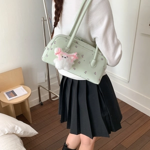 Detail of light green floral shoulder bag with a cute plush bunny charm on a model