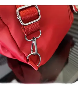 Dettaglio del tessuto Oxford rosso e delle finiture in metallo lucido dello zaino