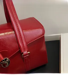 Détail du sac de mariée rouge avec texture polie et fermoir métallique doré élégant