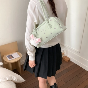 Detail of mint green Boston shoulder bag with pink floral print and plush dog charm