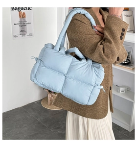 Detail der hellblauen gesteppten Puffer-Tasche mit weich gepolstertem Griff und Kordelzug