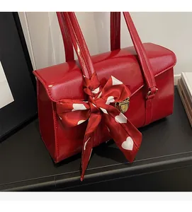 Détail du sac de mariée rouge avec finition brillante, fermoir doré et foulard en soie