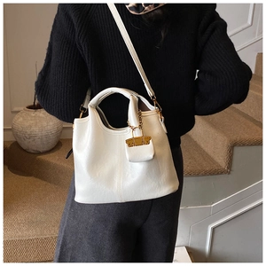 Vue détaillée d'un sac bandoulière blanc minimaliste avec une mini pochette à boucle dorée