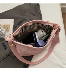 Interno spazioso della borsa a secchiello in tessuto rosa con fodera a righe e zip