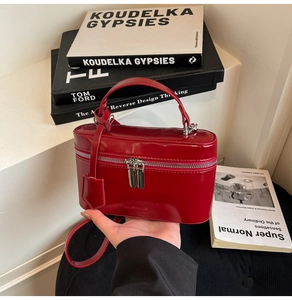 Detailed macro view of a red box bag featuring dual zippers and premium glossy finish
