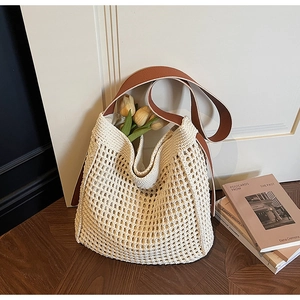 Close-up of bohemian woven tote bag with white cotton mesh and brown leather strap