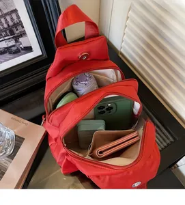 Vista macro dello spazio interno e degli scomparti di una borsa a tracolla in nylon rosso