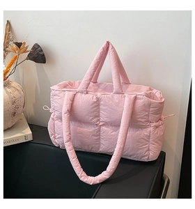 Detail der rosa gesteppten Puffer-Tasche mit weicher Textur und seitlichem Kordelzug