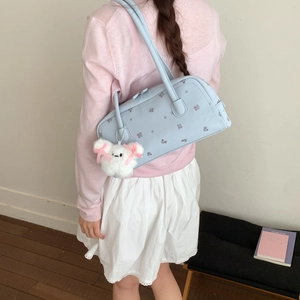 Detail of light blue floral cylinder bag with cute plush animal charm accessory