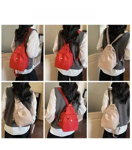 Mini zaino versatile in nylon rosso e beige che mostra diversi stili di trasporto