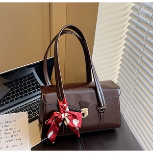 Détail du sac à main vintage en cuir marron avec fermoir doré et accessoire foulard en soie