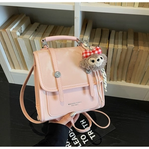 Pink PU leather mini backpack with double buckle flap and plush cartoon charm detail
