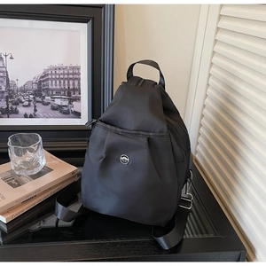 Dettaglio di un piccolo zaino in tessuto Oxford nero con fibbia decorativa in metallo