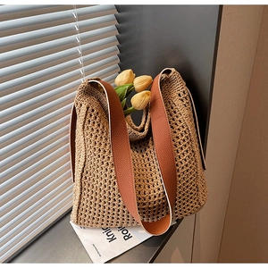Detail of hand-woven beige knit tote bag with brown leather strap and tulip decor