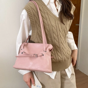Detailed view of light pink pleated tote bag with silver buckle and thin leather straps