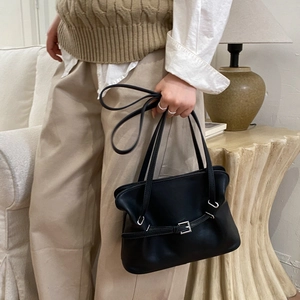 Detail of vintage black leather tote bag with silver buckle and pleated design
