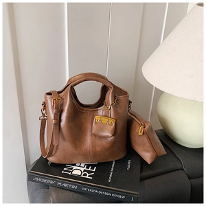 Détail du sac à main vintage marron foncé avec pochette assortie sur livres décoratifs