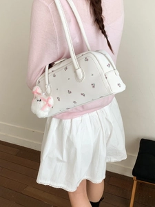 Minimalist white floral shoulder bag with plush bunny charm shown on model back