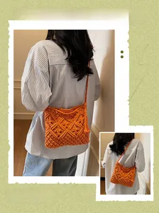 Detail of a bright orange hand-woven cotton rope bag with fringe tassels and diamond patterns