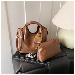 Sac à main vintage en cuir PU marron avec pochette assortie et bandoulière sur canapé noir