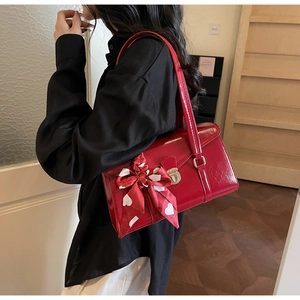 Détail du sac de mariée en cuir verni rouge avec fermoir argenté et foulard en soie