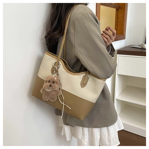 Dettaglio della borsa tote patchwork in tela e pelle marrone con ciondolo a forma di cane