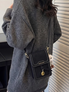 Fashionable black crossbody phone bag with contrast stitching and cute lamb charm accessory