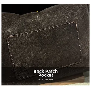 Detailaufnahme der hinteren aufgesetzten Tasche an einer dunklen Leder-Kissentasche